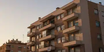 Edificio de apartamentos en una ciudad española con cartel de alquiler, simbolizando el mercado de la vivienda.