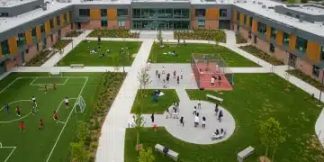 Modern school campus thriving with student activities, reflecting enhanced federal funding for education.